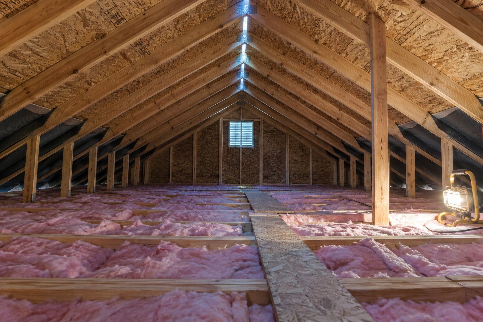 Attic ventilation calculator, Royal Oak: attic with insulation between the joists and daylight from the ridge vent along the peak